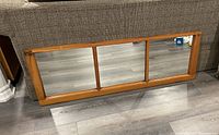 Horizontal three-pane mirror made from a repurposed old farm window, wooden frame with distressed finish showing rustic character.