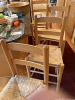 Four wooden bar stools lined up along a kitchen counter, showing overall design and size.