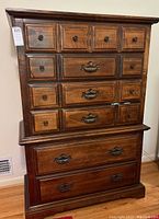 Full view of the wooden chest of drawers showing multiple drawers with metal and wooden handles