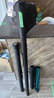 Three black rigid rod tubes and two fabric sleeves standing upright