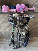 Full view of golf clubs in the bag with some club covers and other accessories nearby.