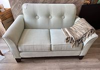 Front view of loveseat with throw draped over right arm