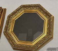 Large ornate octagonal gold framed mirror showing detailed leaf pattern design
