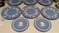 Eight Wedgwood jasperware plates in blue with white bas relief, six large circular plates and two smaller plates.