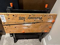 Top view of Workmate 400 workbench laid flat, showing branded wooden surface with holes and clamps.