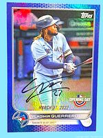 Front of the 2022 Topps Blue Vladimir Guerrero Jr. baseball card showing the player in action and a holographic background, with a visible on-card signature in black ink.