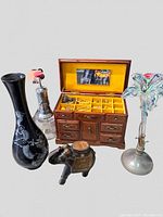 Overall photo showing all items together: wooden jewelry box, black Asian vase with mother of pearl dragon, glass flower vase, silver metal bottle and small carved elephant figurine