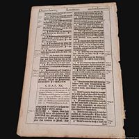 Full view of the single antique Bible leaf showing text from Leviticus chapter 19 and 20, printed in blackletter typeface, including marginal notes and ornate initials. Paper shows age wear and slight discoloration.