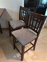 Front view of two chairs showing seat fabric and ladder back design
