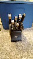 Front view of Marburg knives with metal handles in black knife block showing logo.