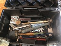 Open Stanley Fatmax toolbox containing hammers, wrenches, and other hand tools in bottom compartment.