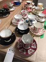 Overview of 8 assorted tea cups and saucers with various floral and solid color designs from different brands.