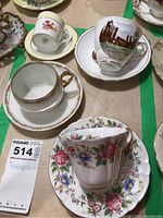 Three tea cups and saucers plus one demitasse cup and saucer arranged on table, showing front views and overall set appearance