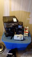Photo showing four kitchen appliances and gadget: Hamilton Beach FlexBrew coffee maker, Black and Decker grinder and mixer, and manual French fry cutter.