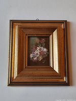 Front view of the miniature floral painting in wood and gold-toned frame.
