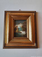 Front view of the miniature framed painting showing the castle landscape and ornate gold frame.