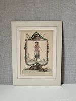 Antique French fashion plate mounted on backing board, featuring an 18th century male figure in fashionable dress surrounded by decorative elements.