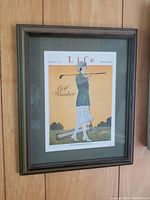 Framed vintage 1921 Life Magazine Golf Number print with woman holding golf club on orange background. Print measures 9.5 x 12 inches, frame 12 x 14 inches.