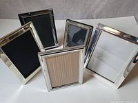 Front view of all 5 vintage silver photo frames showing various silver plated designs and finishes.