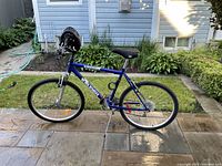 Side view of electric blue Ambush Raleigh 10-speed bicycle with gel seat and mounted helmet.