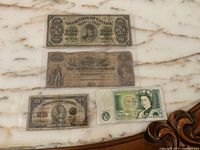 Front faces of all four banknotes arranged on marble surface