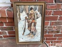 Full view of framed watercolor painting leaning against brick wall
