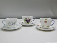 Three Shelley English fine bone china teacups and saucers displayed side by side showing the floral decoration and shapes