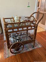 Front and left side view of bamboo tea cart showing bamboo construction, glass shelves, and tea service items placed on the cart (contents not included).