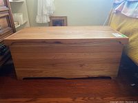 Front view of the rectangular wooden blanket box, showing the finished wood grain surface and closed lid.