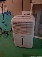Full view of the white Kenmore dehumidifier showing front vents and overall shape.