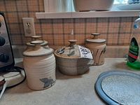 Four pieces of pottery on a kitchen counter showing overall set and arrangement