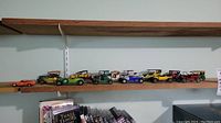 Full shelf of 11 vintage metal collectible Lesney cars including General Lee car and various early 1900s models.
