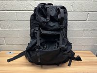 Front view of black Fieldline Delta 65 tactical internal frame hiking backpack showing main compartment, padded straps, and MOLLE webbing on sides.