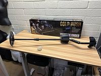 Full view of the Gold Rush metal detector laid out on a table with the original box behind it.