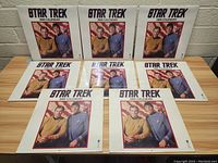 Seven sealed Star Trek 1995 calendars arranged on a wooden table showing front covers with Star Trek characters.