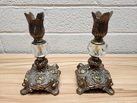Front view of the pair of vintage brass candlesticks showing the detailed base, glass element, and tulip-shaped candle holders.