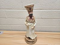Side front view of the vintage German porcelain figurine showing the man wearing traditional attire with 'DRAHTZPE' inscribed on the base.