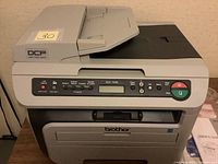 Front view of Brother DCP-7040 multifunction printer/scanner showing control panel, LCD screen, and document feeder.