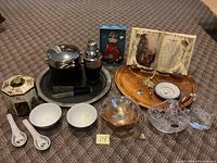 Full lot overview showing all decorative items including bar set, doll, crystal basket, ceramic dishes, and wooden tray