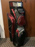 Side view of ladies golf bag showing black, burgundy and gray color scheme, and zippered pockets.