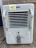Front view of white Super brand electric heater. Shows two control knobs and carry handle on top.