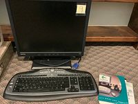 BenQ 17-inch monitor with wired Logitech keyboard placed on carpet floor.