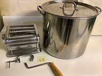 Photo showing the Exceline branded pasta maker, clamp, crank, and 15 quart stainless steel pot with lid side by side.