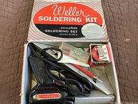 Overview of the Weller soldering kit with gun, tips, solder wire, and box.