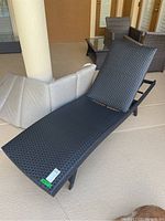 Photo of the dark faux wicker lounger with no cushion, adjustable backrest visible