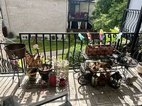 Photo shows the entire patio setup with cart, table, and multiple decor items on a balcony overlooking a garden.