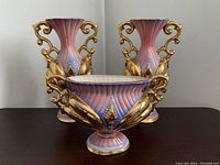 Front angle view of the three-piece Italian vintage porcelain vase set with pink, blue, and gold detailing.