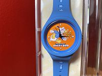 Close-up of the watch dial showing Donald Duck and text 'The Original Angry Bird' on an orange background