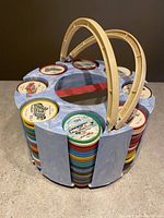 Circular holder with multicolored vintage Jell-O picture tokens stacked in slots, showing one broken handle
