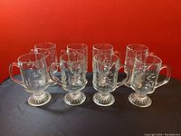 Front view of all 8 vintage Princess House Heritage Irish coffee mugs, showing clear etched glass design and pedestal bases.